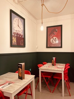Mesas del comedor con sillas rojas y pósters vintage