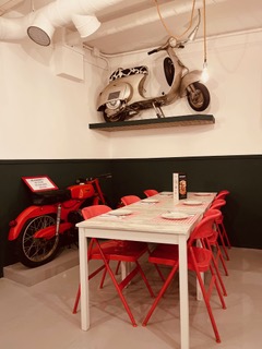 Mesa junto a vespa decorativa colgada en la pared